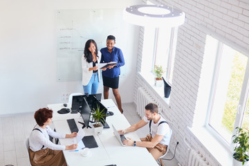 Obraz premium Business for people. Young staff having conversation with african coach, businesswoman, Smiling, laughing