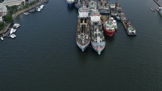 Aerial reveal of empty cargo ships in old harbor, Jakarta, Dolly In