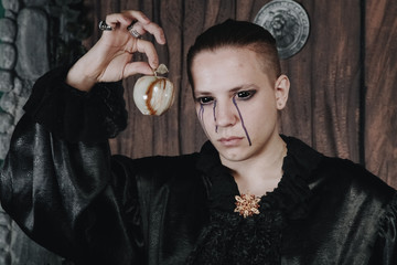 halloween make up. scary man ready for party. vampire guy with black eyes and tears in a black silk...