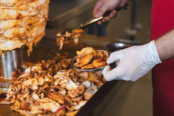 Chef preparing and making Traditional Turkish Doner Kebab meat. Shawarma or gyros. Turkish, greek or middle eastern arab style chicken doner kebab food on isolated white. - obrazy, fototapety, plakaty