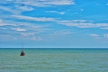 Fishing boat floating in the sea with blue sky.
