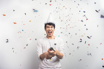 Asian man fun celebrating Christmas or New Year party confetti. Happy new year concept.