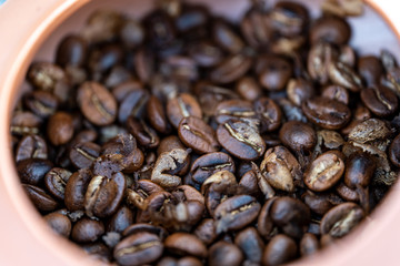 Roasted Coffee beans in hands on dark background