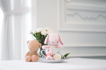 Fototapeta na wymiar bunny and teddy. Cute stuffed animals of pink rabbit doll and brown teddy bear sitting together. Love and friendship concept. Soft focus on the bunny doll.