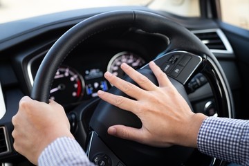 hand on steering wheel of car