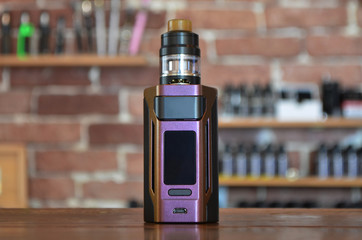 Electronic cigarette on a background of vape shop. E-cigarette for vaping.