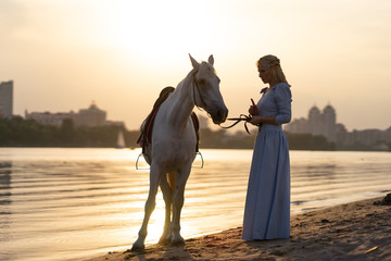 blonde in a blue dress with a horse