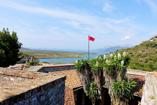Flag of Albania over the Byzantine fortress and the ruins of the ancient Greek city of Butring