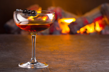Manhattan cocktail on fireplace background