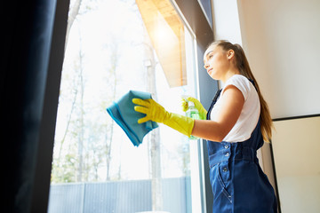 Industrious woman with rug, wearing yellow rubber gloves do cleaning of window glass. panoramic window