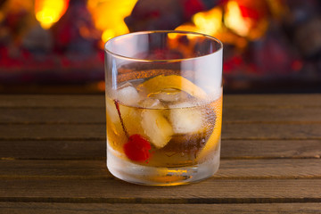 Old Fashion cocktail on fireplace background