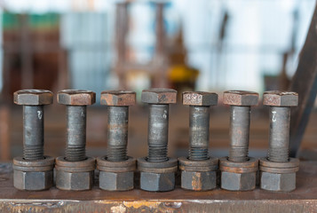 Seven bolt, nut and washer placed on a steel plate.blurred background