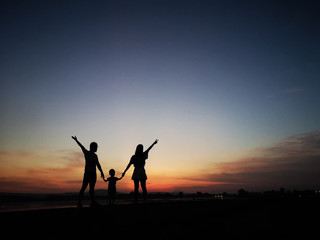 silhouette of happy family father mother and son at sunset, Silhouette of a family enjoying a beautiful sunset