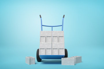 Obraz premium 3d rendering of stack of grey hollow bricks on blue hand truck with several bricks lying on ground on light-blue background.