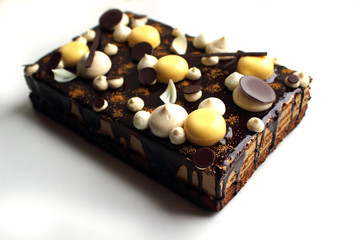 Coffee and hazelnut sheet cake with mirror glaze, orange mousse and chocolate decorations