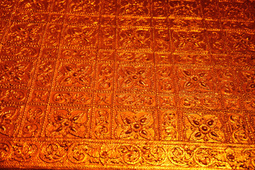 Close up of a golden wall designed with flowers inside the Buddhist Botataung pagoda, Yangon, Myanmar.