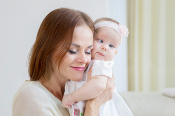Affectionate mother embracing her baby at home