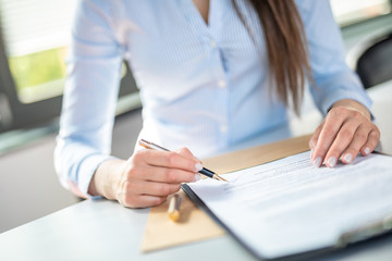 Business woman signing contract, making a deal.