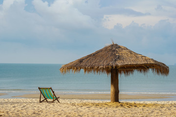 The morning sea has chairs and umbrellas on the beach as the foreground and the sea with the sky as the background.