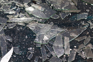 Shards of transparent glass, of various shapes and sizes, on a black background