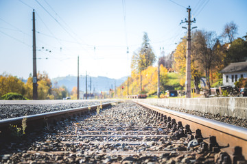 Sustainable traveling by train: Rail track and colorful, idyllic landscape in fall.
