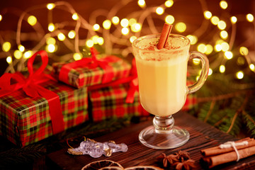 Traditional Homemade Winter Eggnog Cocktail with Whipped Cream and Cinnamon for Christmas Eve and Winter Holidays. Selective Focus. Copy Space. Toned image.