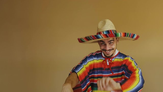 Young Mexican In Multicolored Poncho And Hat.