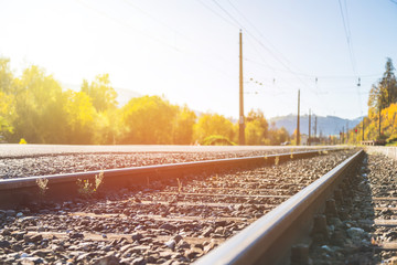 Sustainable traveling by train: Rail track and colorful, idyllic landscape in fall.