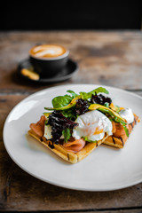 Breakfast, waffles with salmon and poached egg and coffee