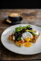 Breakfast, waffles with salmon and poached egg and coffee