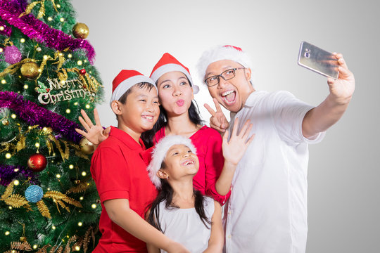 Cheerful family takes selfie near a Christmas tree