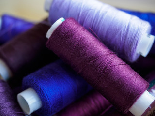Lots of bobbins of thread for sewing. Threads of different colors.