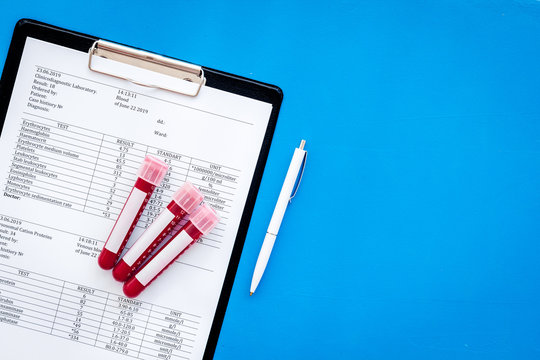 Blood test results on blue background top view copy space