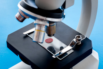 Blood testing. Samples viewing undermicroscope on blue background top view