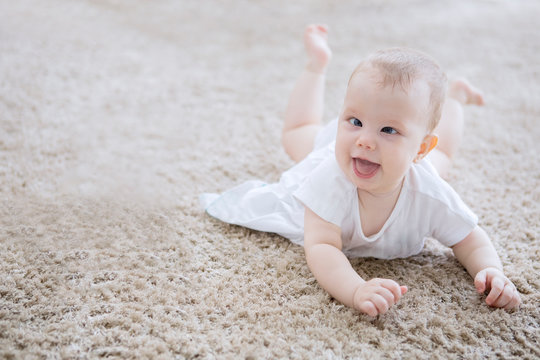Cute baby girl creeping on the fur carpet