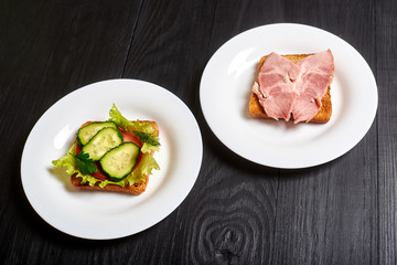 Sandwich with vegetables and a sandwich with meat. The choice between vegetarianism and meat-eating.