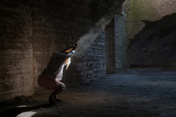 A woman in a dark cave illuminated by a ray of light.