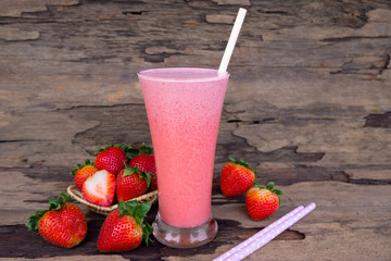 Strawberry smoothies colorful pink fruit juice milkshake blend beverage healthy high protein the taste yummy In glass,drink episode morning on wood background.