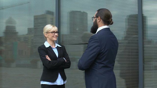 Businesspeople discussing cooperation plan on informal meeting outdoors, chat