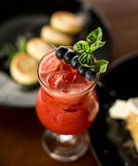 Berry smoothie with strawberries and blueberries, basil, ice, red refreshing cocktail