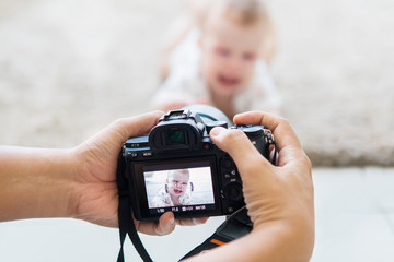 Hands of photographer take a photo of a cute baby