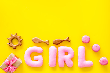 Girls's birthday concept. Pink baby set with gift box on yellow backgound top view frame space for text