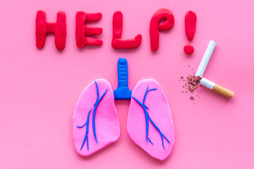 Harm of smoking and cancer. Word help, lungs and cigaretts on pink background top view