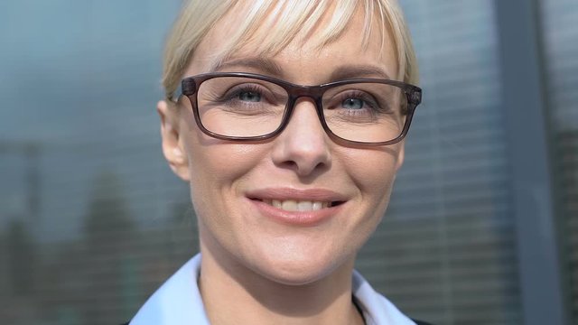 Cheerful business lady in glasses looking to camera feeling proud and inspired