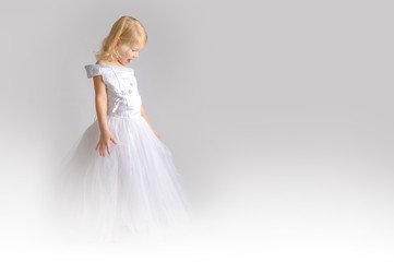 little girl in a wedding dress. pretty little girl in beautiful white dress isolated on light background. Copy space