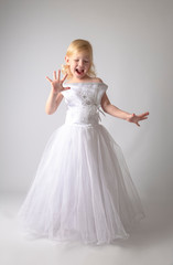 Fototapeta na wymiar little girl in a wedding dress. pretty little girl in beautiful white dress isolated on light background
