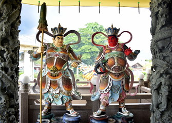 Colorful warrior statues outside a Chinese temple