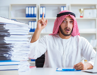 Arab businessman working in the office doing paperwork with a pi