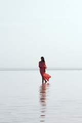 Woman walking at sea at sunset. Beach Summer Holiday Vacation Traveling Relaxation Concept 