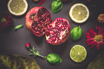 Fruit collage on black background with flowers and basil leaves